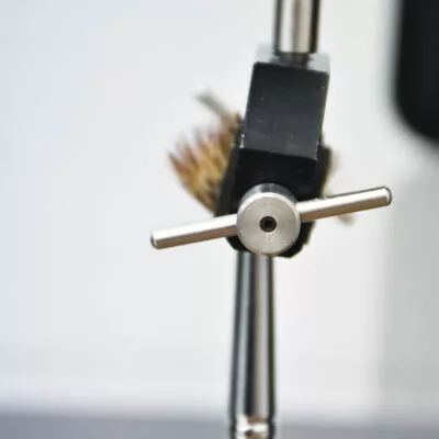 Close-up of a lab technician testing makeup brushes for durability and performance
