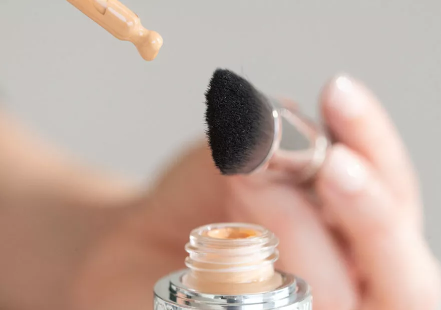 Utilisation d'un pinceau D-Brush de Raphaël pour l'application de fond de teint liquide, gros plan esthétique