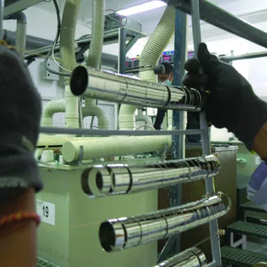 Worker handling metal ferrules in an electroplating line to enhance durability and shine