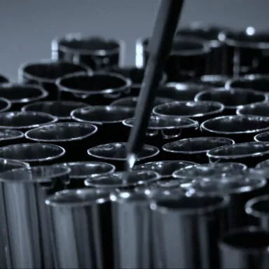 Close-up of multiple shiny metal brush ferrules arranged in a production setting