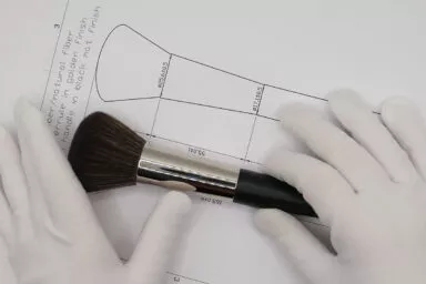 Vérification des dimensions d’un pinceau sur plan technique, illustrant la rigueur du contrôle qualité
