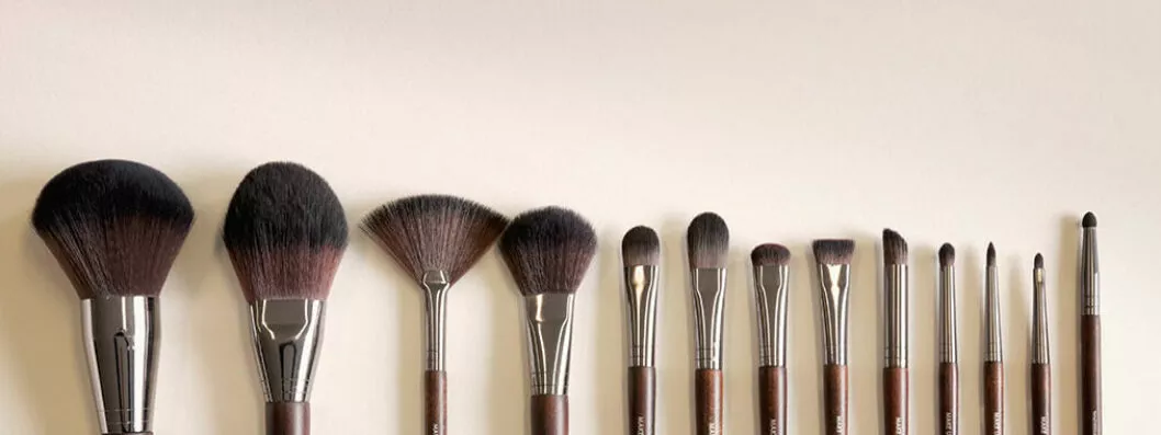 Collection de pinceaux de maquillage sur mesure alignés sur fond neutre
