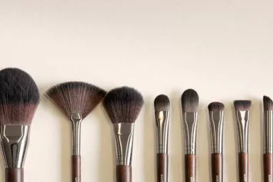 Collection de pinceaux de maquillage sur mesure alignés sur fond neutre