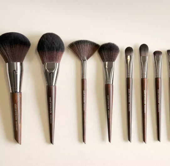 Collection de pinceaux de maquillage sur mesure alignés sur fond neutre pour présentation produit