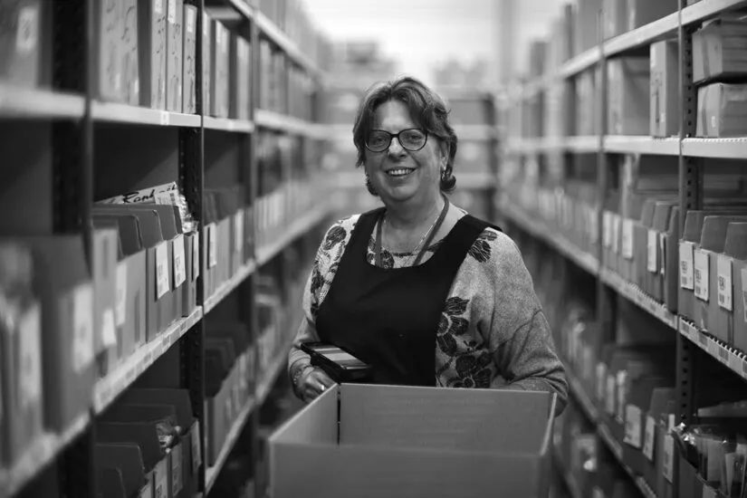 Portrait d’une employée souriante dans l’entrepôt logistique de l’usine Raphaël