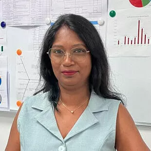 Aruna, responsable qualité, assise à son bureau devant des graphiques de performance