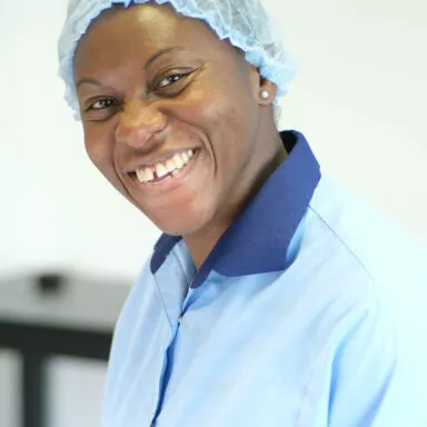 Nicole, responsable qualité chez Raphaël, en blouse bleue avec pinceaux en main