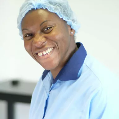 Nicole, Raphaël manufacture worker, smiling while performing quality control on professional makeup brushes – made in France excellence