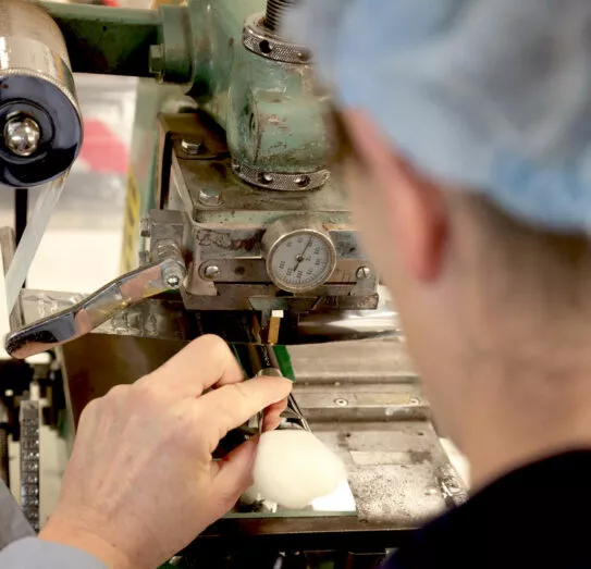 Close-up of artisan at Raphaël using hot stamping machine to mark brush handles – traditional French craftsmanship