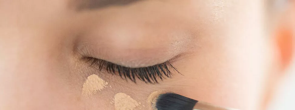 Application de correcteur avec pinceau cosmétique Raphaël sous les yeux