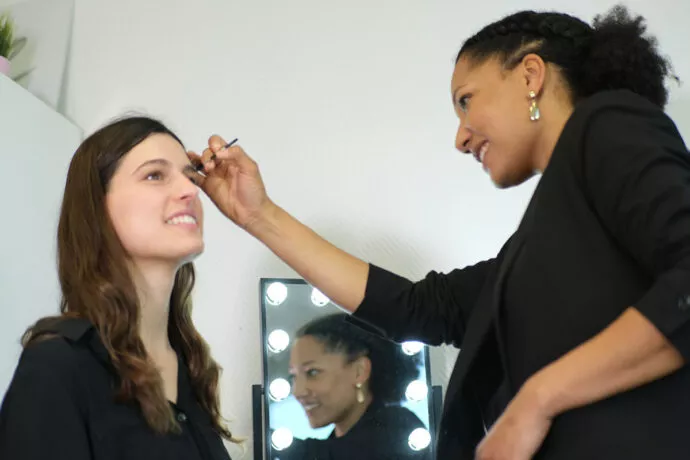 Séance de maquillage avec pinceaux Raphaël devant un miroir éclairé type loge professionnelle